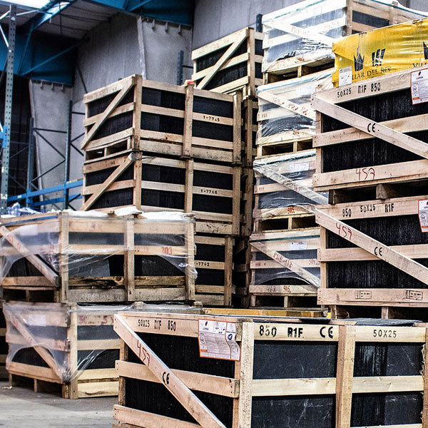Gestapelte Holzkisten mit Steinplatten in einer Lagerhalle