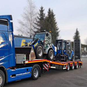 Ein Tieflader transportiert Baumaschinen hinter einem Endras-Lkw