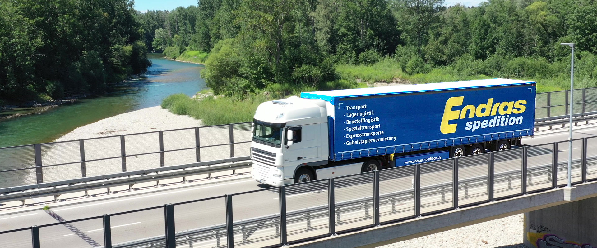 Blauer Sattelzug der Endras-Spedition auf einer Brücke